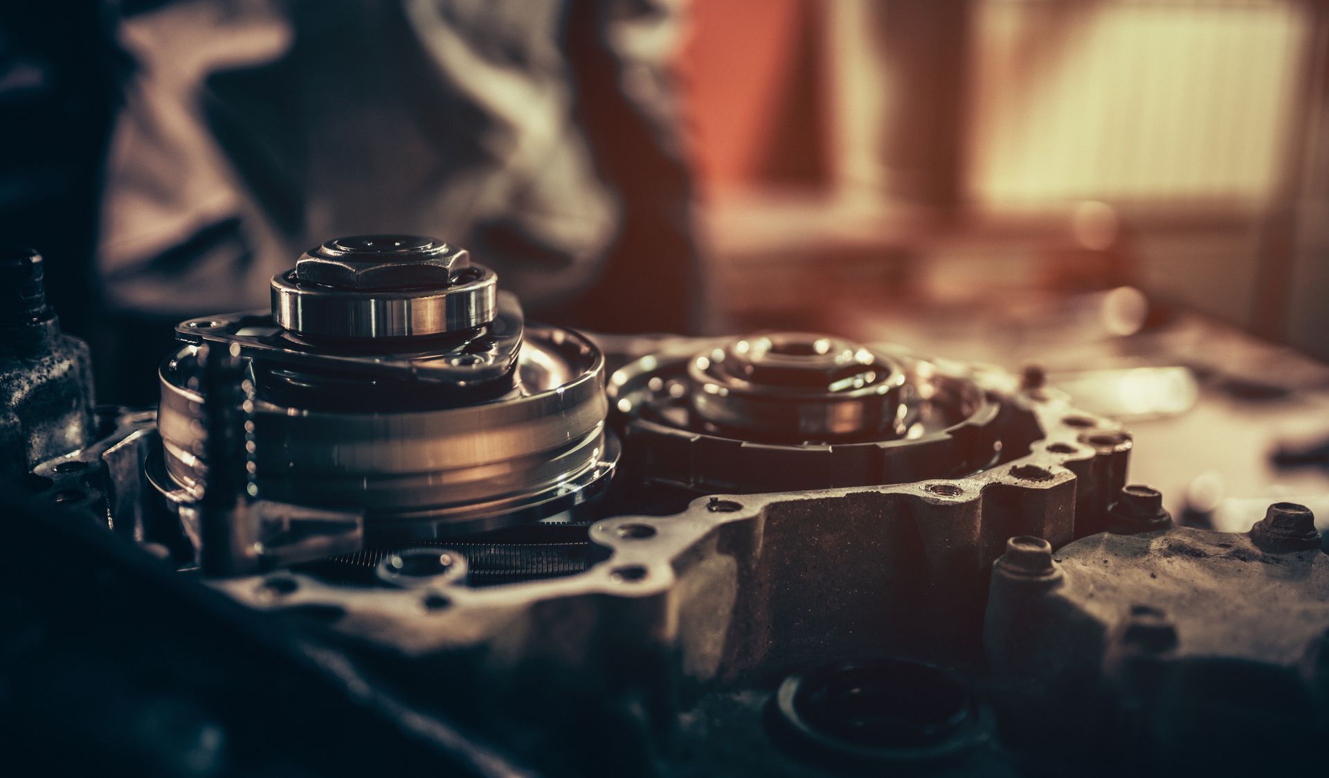 A person is working on a gearbox with a wrench.