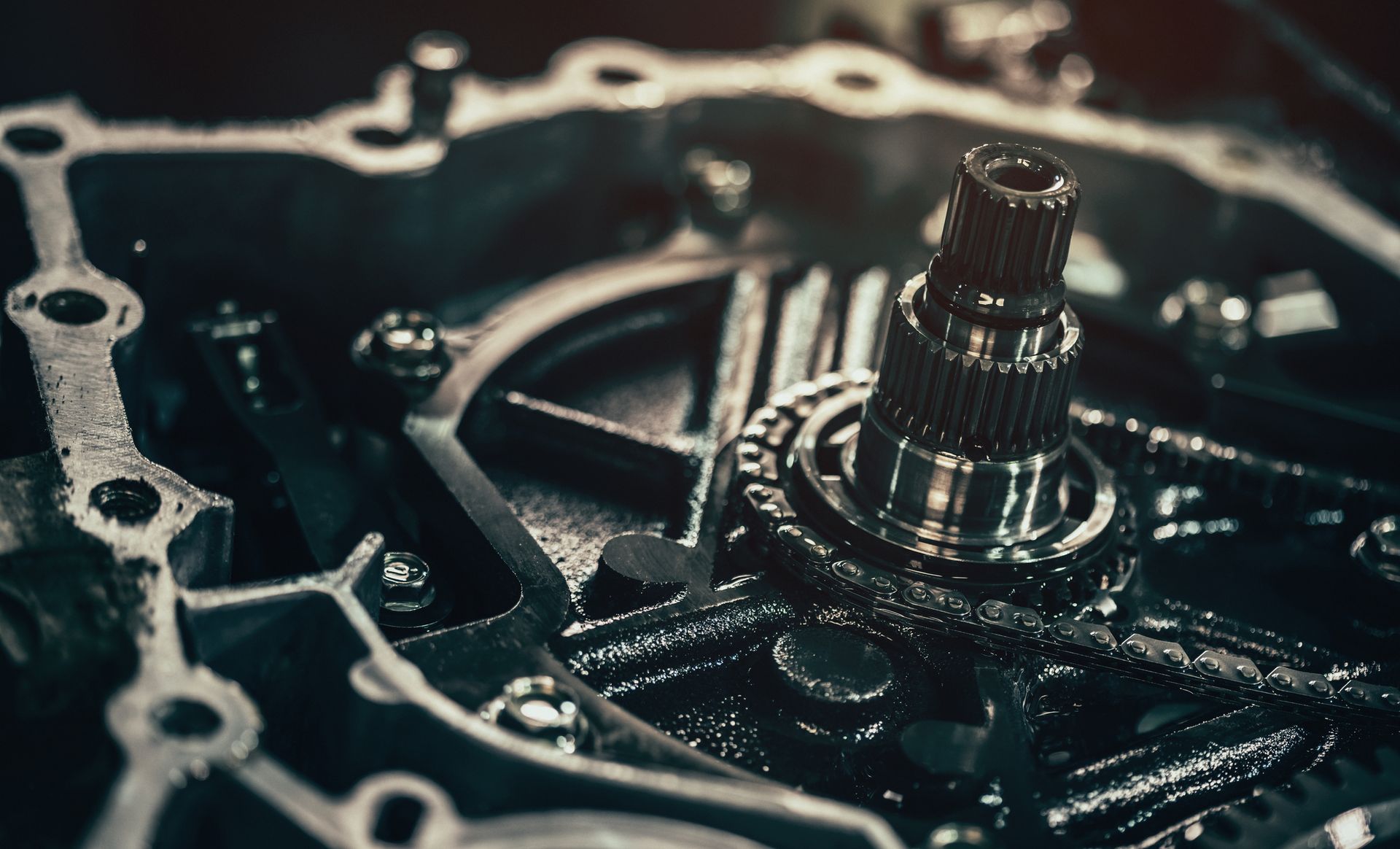 A man is working on a gearbox with a wrench.