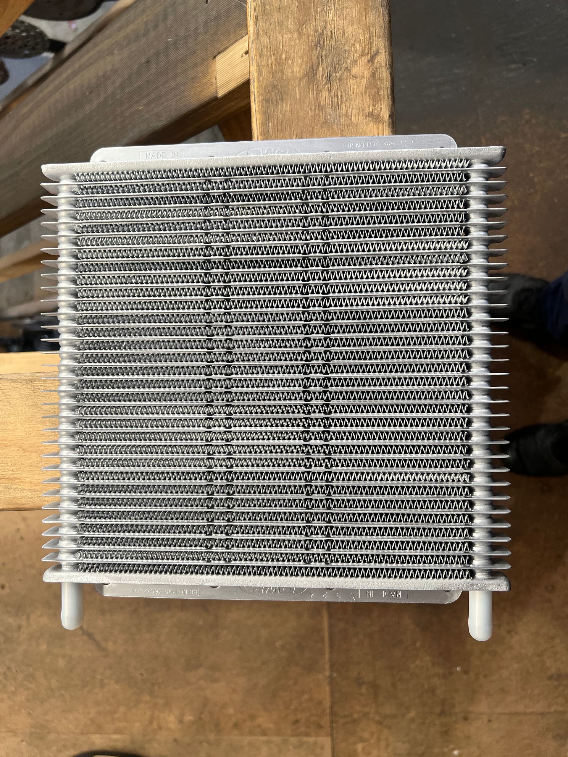 A man is working on the radiator of a car.