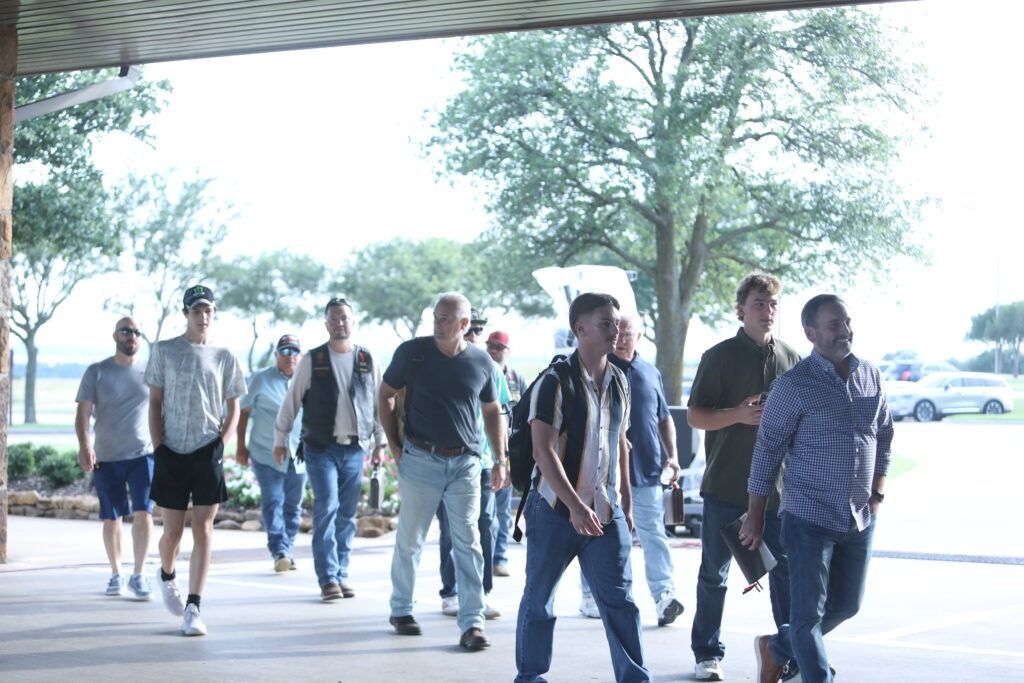 People walking together under a covered outdoor walkway on a bright day.