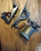 A couple of tools hanging on a wooden wall.