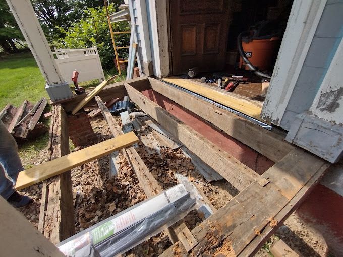 A wooden deck is being built on the side of a house.