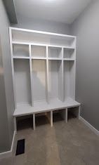 A room with a bench and shelves in it.