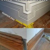 A corner of a room with a wooden floor and a white trim.