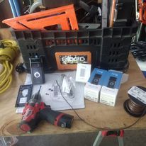 A bunch of tools are sitting on top of a wooden table.