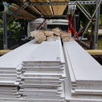 A stack of white boards sitting on top of a scaffolding.