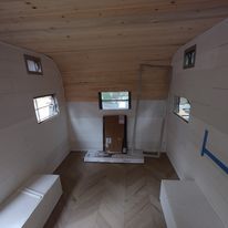 A small room with a wooden floor and a wooden ceiling.