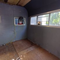 A room with a lot of windows and a fan on the wall.