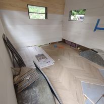 A room with a wooden floor and a window.