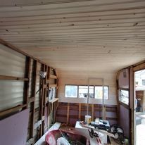 A room with a wooden ceiling and a lot of windows.