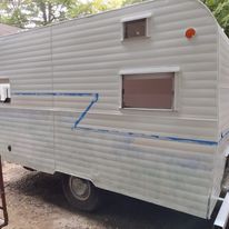 A white trailer is parked on the side of the road.
