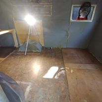 A room with a tent and a light on the floor.