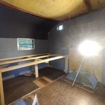 A room with a light on a tripod in it.