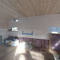 A room with a wooden ceiling and a purple wall.