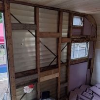 A camper is being remodeled with a lot of wood and foam.