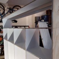 A shelf with a bicycle on top of it in a garage.