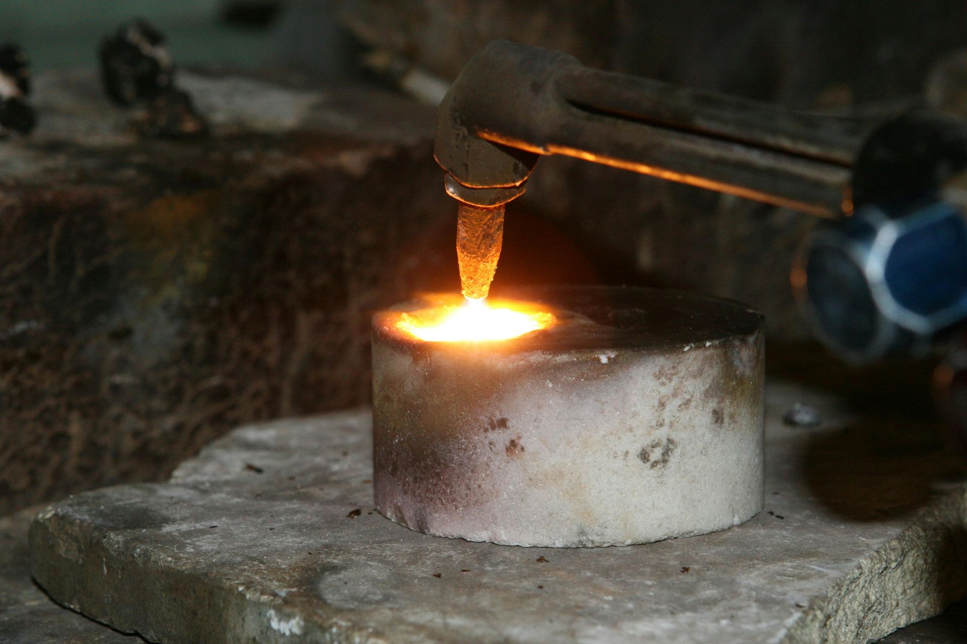 A piece of metal is being heated by a torch.