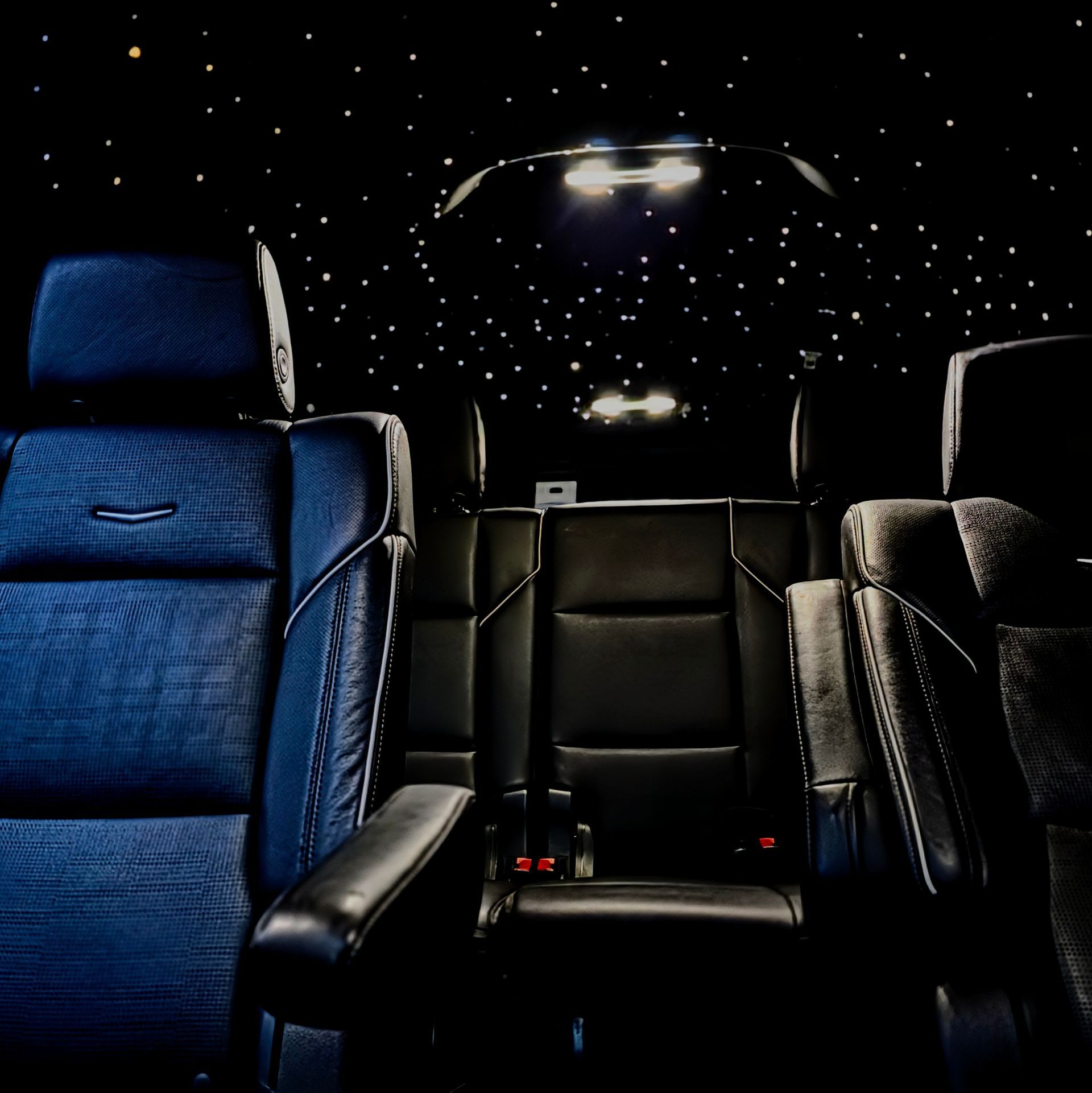 Black leather car interior with starry ceiling lights.