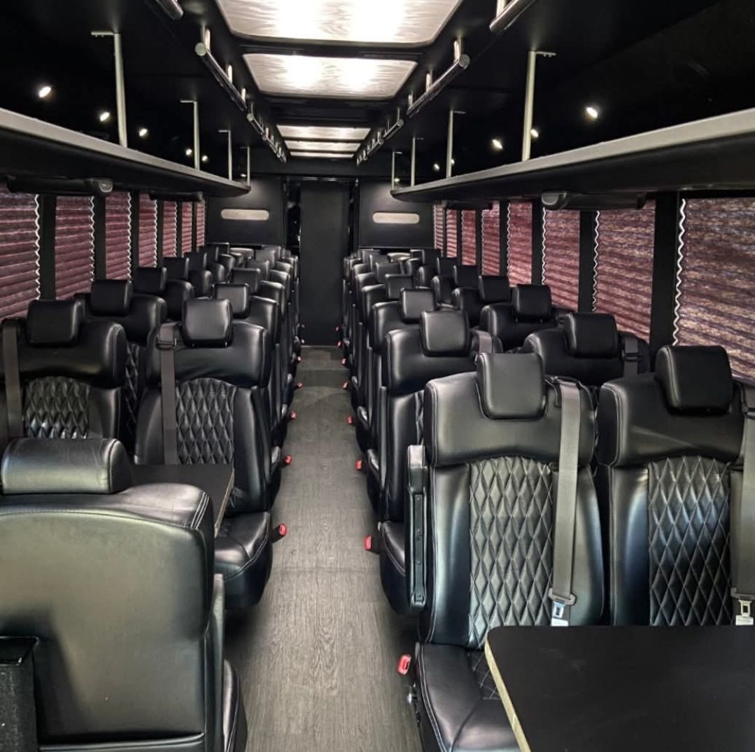 Teams shuttle bus service or large group The inside of a bus with black seats and tables