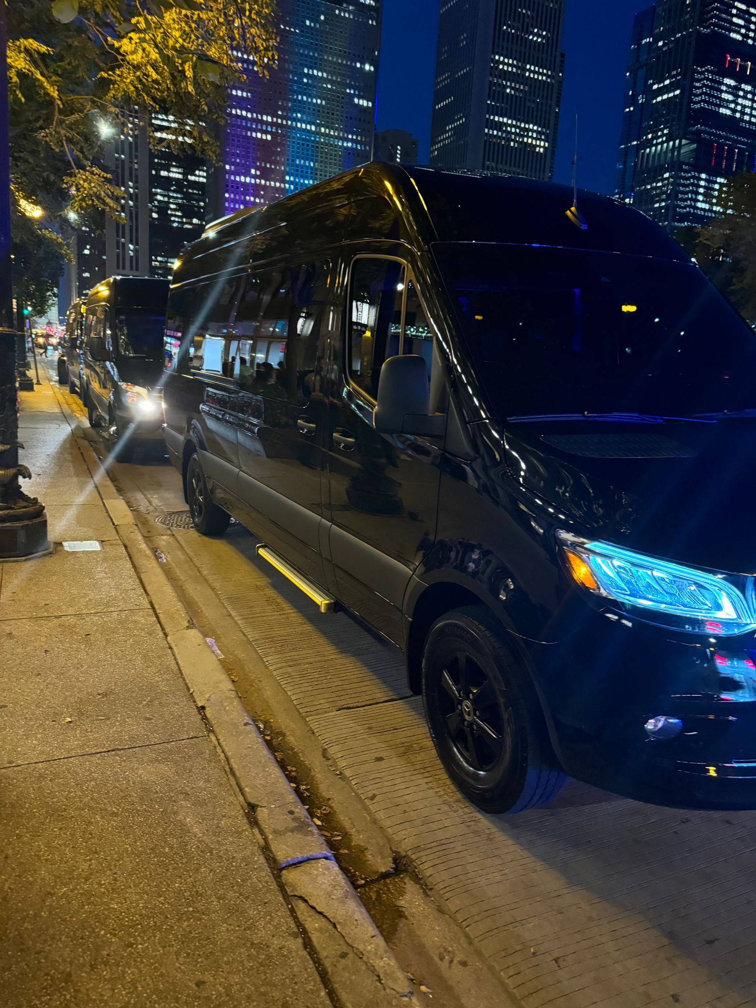 Executive Sprinters charter services A black van is parked on the side of the road at night.