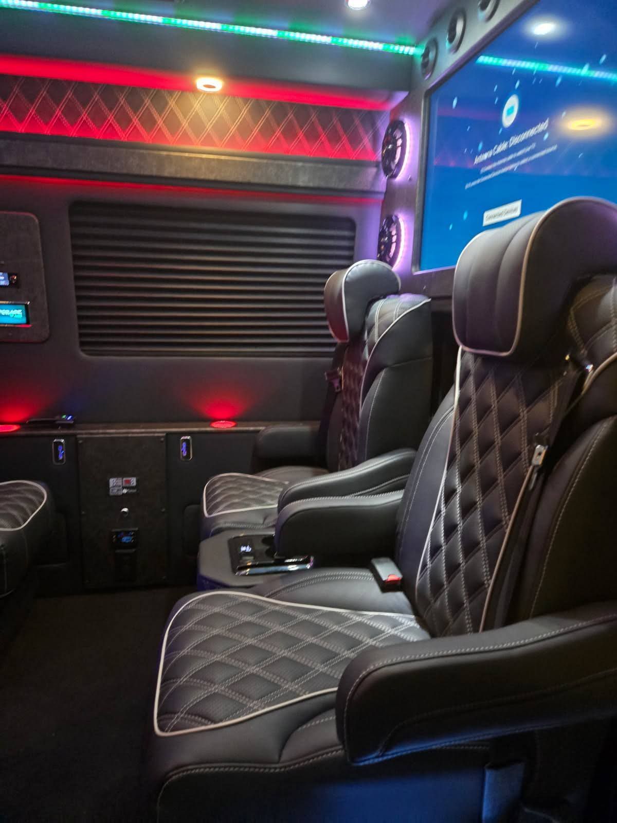 The interior of a van with a large screen on the wall.