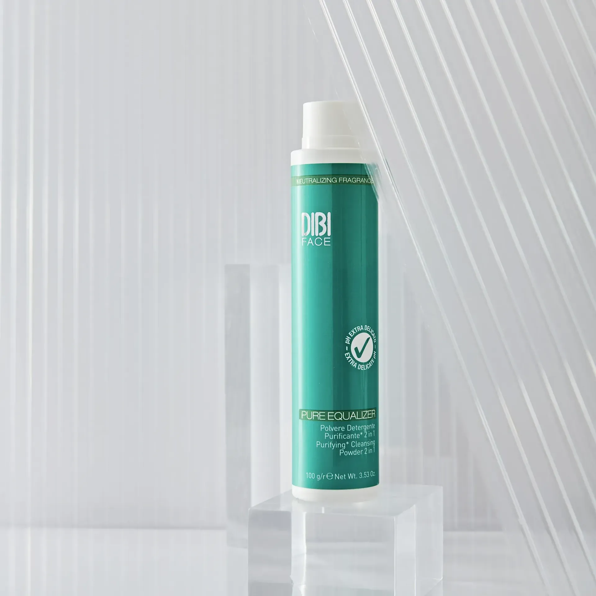 Flacone alto color verde acqua di Dibi Milano su un blocco trasparente. Tappo bianco. Sfondo bianco astratto.