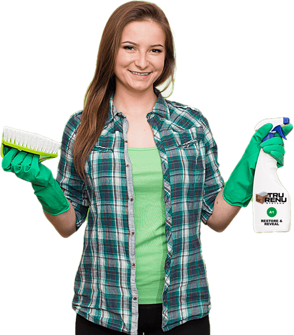 A woman in a plaid shirt is holding a spray bottle and a brush.