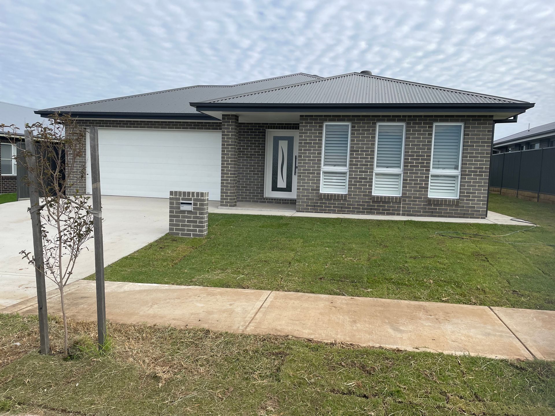 The front of a brick house with a white garage door