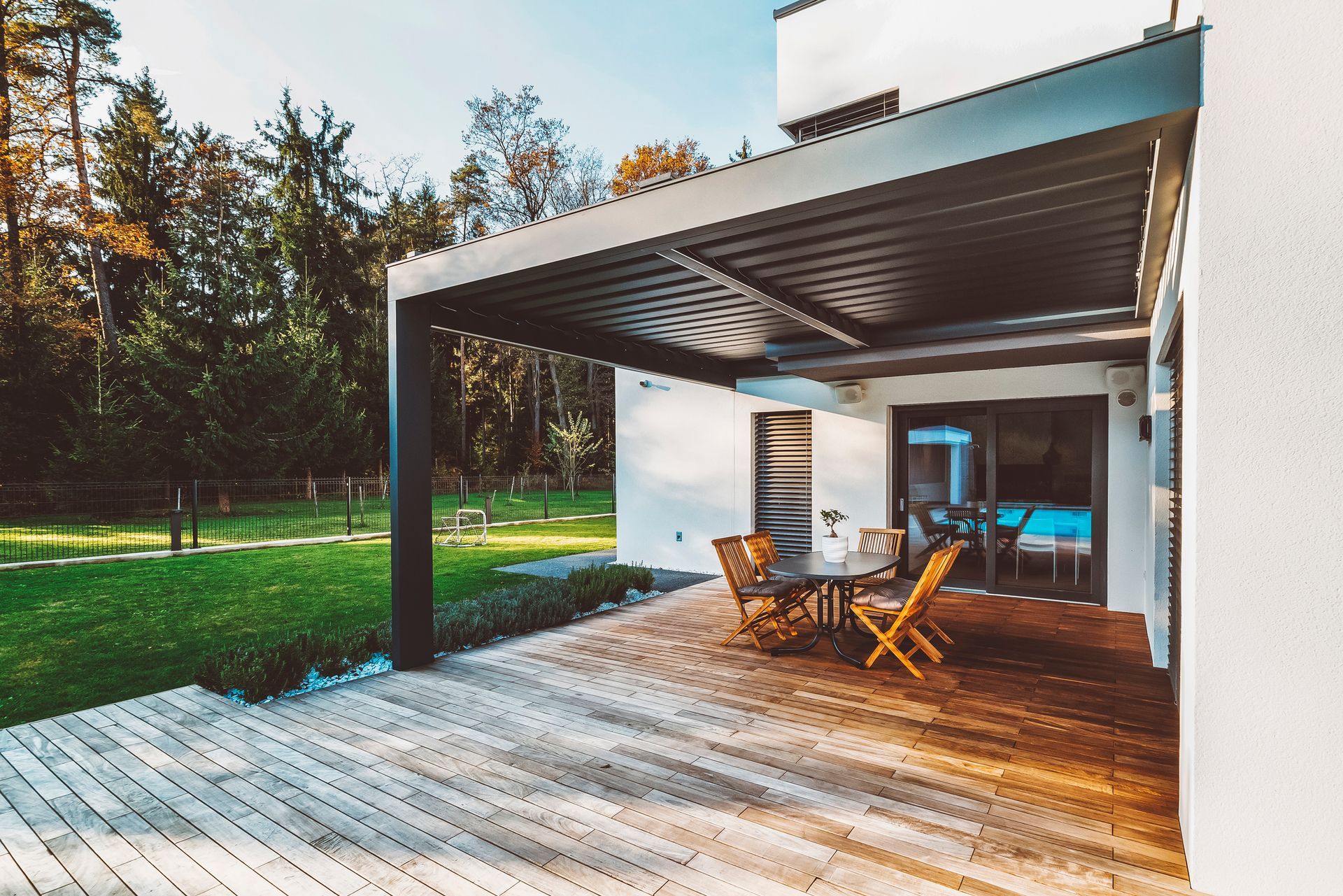 A tape measure , pencil , and square are on a wooden deck.