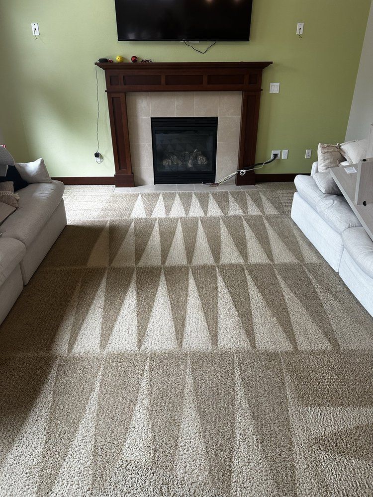 Living room with fireplace, TV, patterned rug, and sofas on both sides