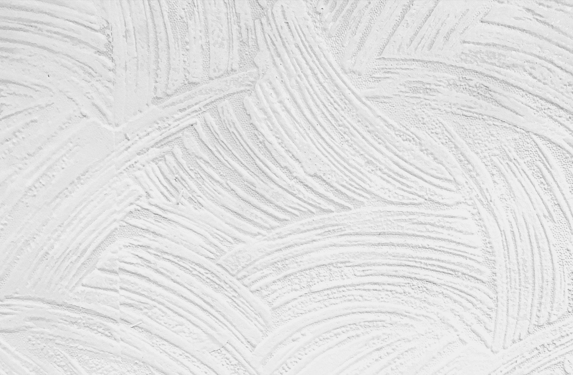 A close up of a white wall with a brush stroke pattern.