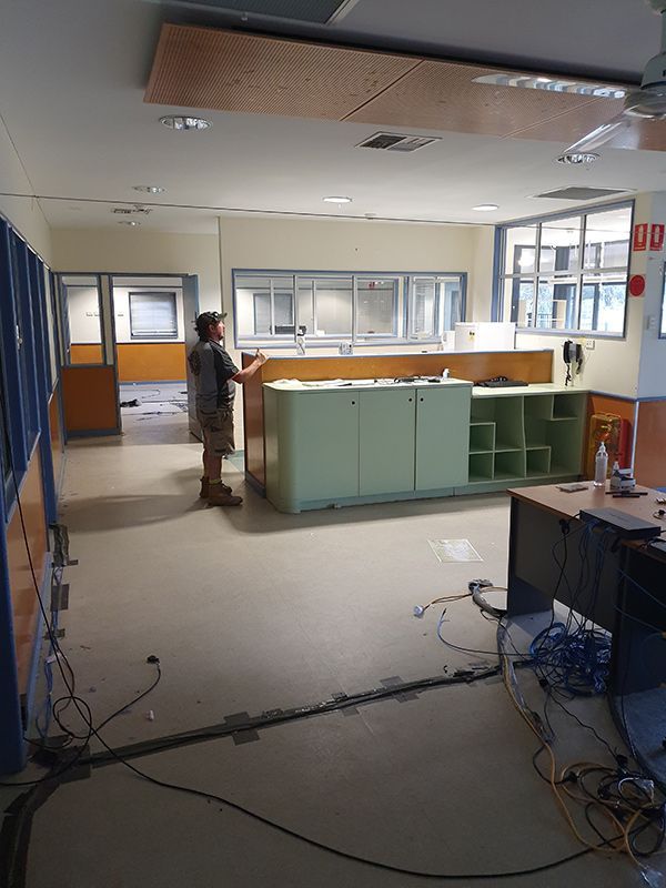 A Worker Is Standing In A Room With A Lot Of Wires On The Floor — Entire Trades in Cessnock, NSW