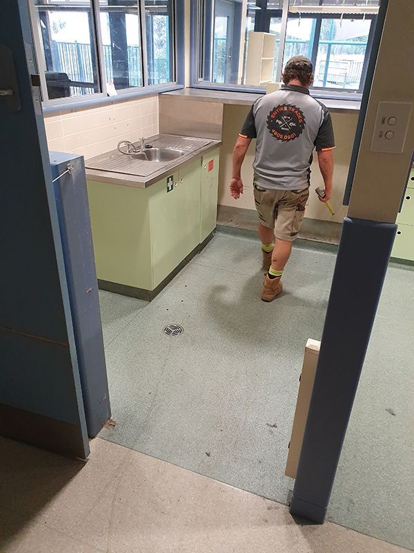 A Carpenter Man Wearing An Entire Trades Shirt Walks Through A Kitchen With A Sink — Entire Trades in Port Stephens, NSW