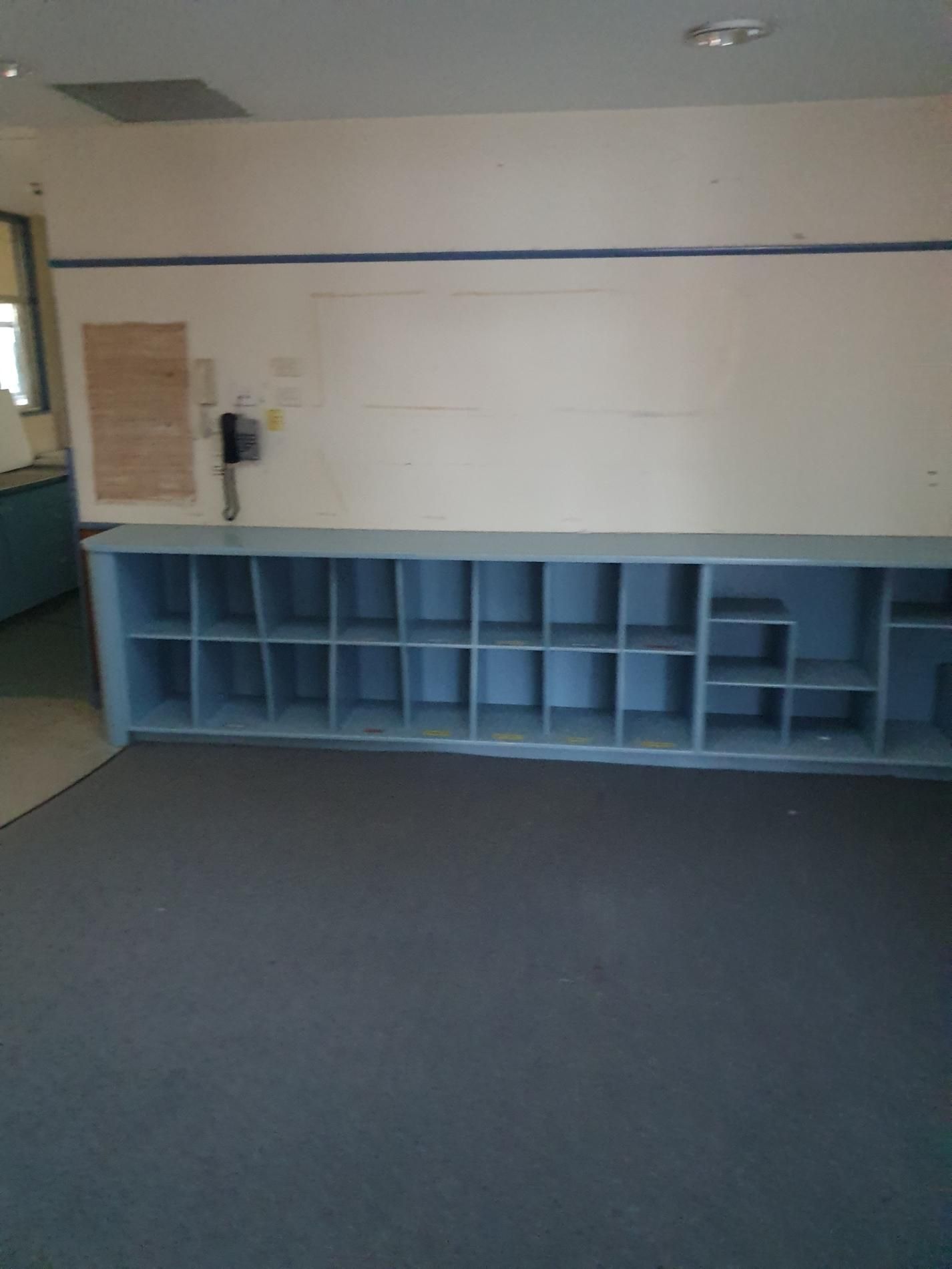 An Empty Classroom with Blue Shelves and A White Board — Entire Trades in Singleton, NSW