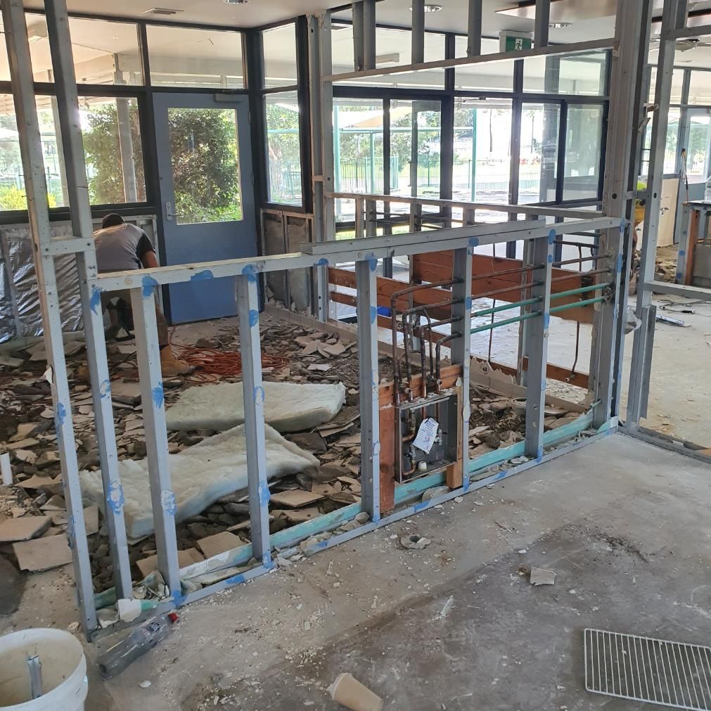 A Room that Is Being Remodeled with A Bucket of Cement on The Floor — Entire Trades in Singleton, NSW