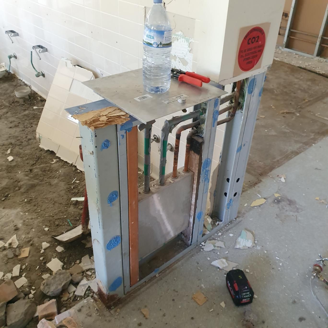 A Bottle of Water Sits on Top of A Metal Shelf — Entire Trades in Singleton, NSW