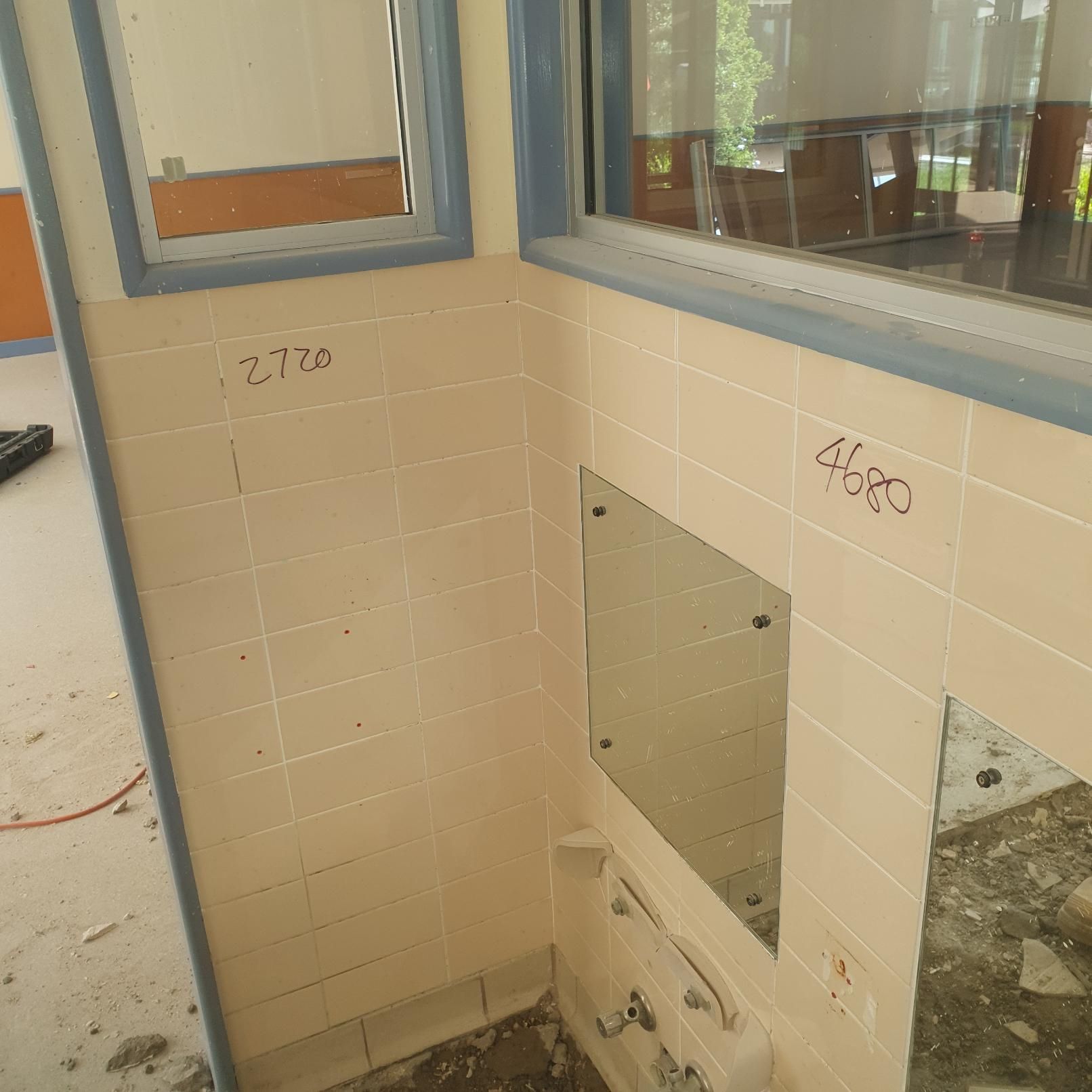 A Bathroom with A Mirror and A Window with Numbers Written on The Wall — Entire Trades in Singleton, NSW