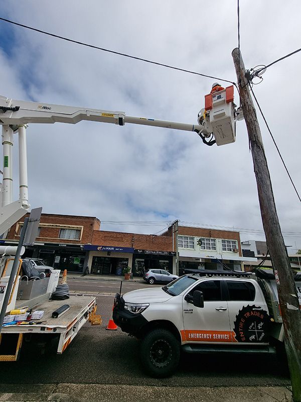 Person Repairing The Electrical Wiring On The Pole — Entire Trades in Central Coast, NSW