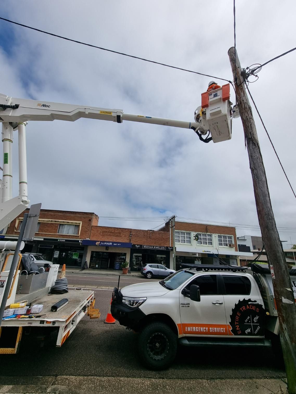 A White Truck Is Parked Next to A Pole with A Crane Attached to It — Entire Trades in Maitland, NSW