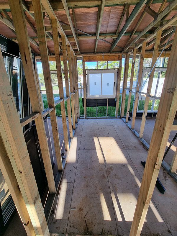The House Is Under Construction With Wooden Beams And A Window — Entire Trades in Central Coast, NSW