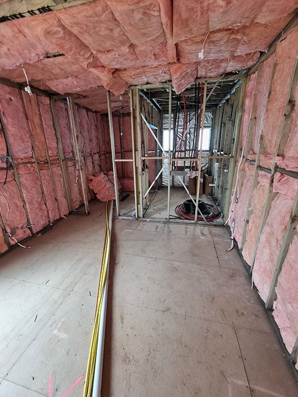 A Room With Pink Insulation On The Walls And Ceiling — Entire Trades in Central Coast, NSW