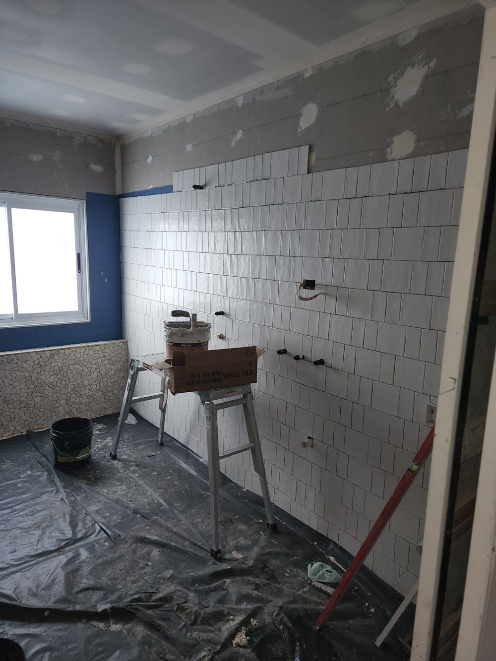 A Room With White Tiles On The Wall And A Ladder — Entire Trades in Central Coast, NSW
