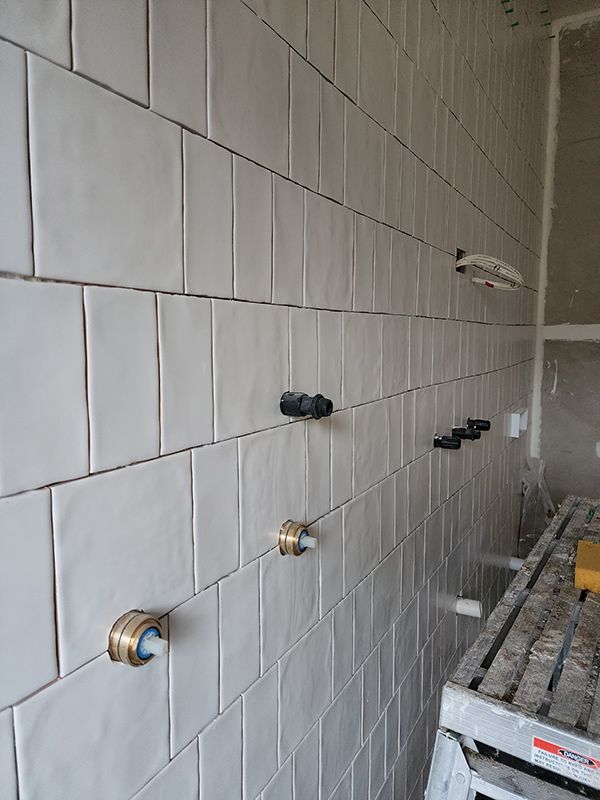 Sink In A Bathroom With White Tile Wall And Electrical Cable And Pipe For The Sink And Faucet — Entire Trades in Cessnock, NSW