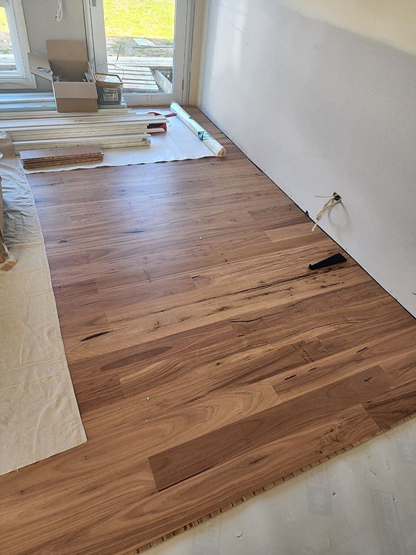 A Wooden Floor Is Being Installed In A Room — Entire Trades in Central Coast, NSW