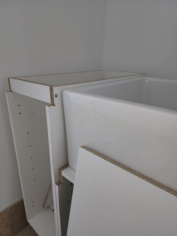 A White Cabinet Is Sitting Next To A White Sink In A Corner Of A Room — Entire Trades in Singleton, NSW