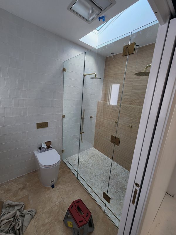 A Bathroom With A Toilet, Large Shower Room Area And Skylight — Entire Trades in Singleton, NSW