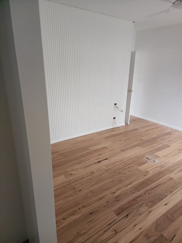 A Room With Hardwood Floors And White Walls With Outlet Cable — Entire Trades in Cessnock, NSW