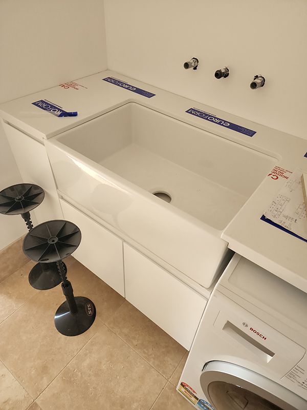 A Laundry Room With A Sink And A Washing Machine — Entire Trades in Central Coast, NSW