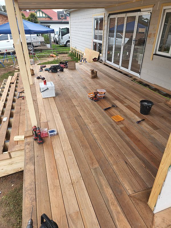 A Wooden Deck Is Being Built In Front Of A House — Entire Trades in Maitland, NSW