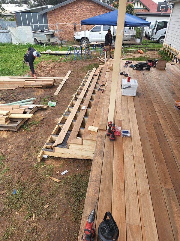 A Wooden Deck Is Being Built In The Backyard Of A House — Entire Trades in Central Coast, NSW